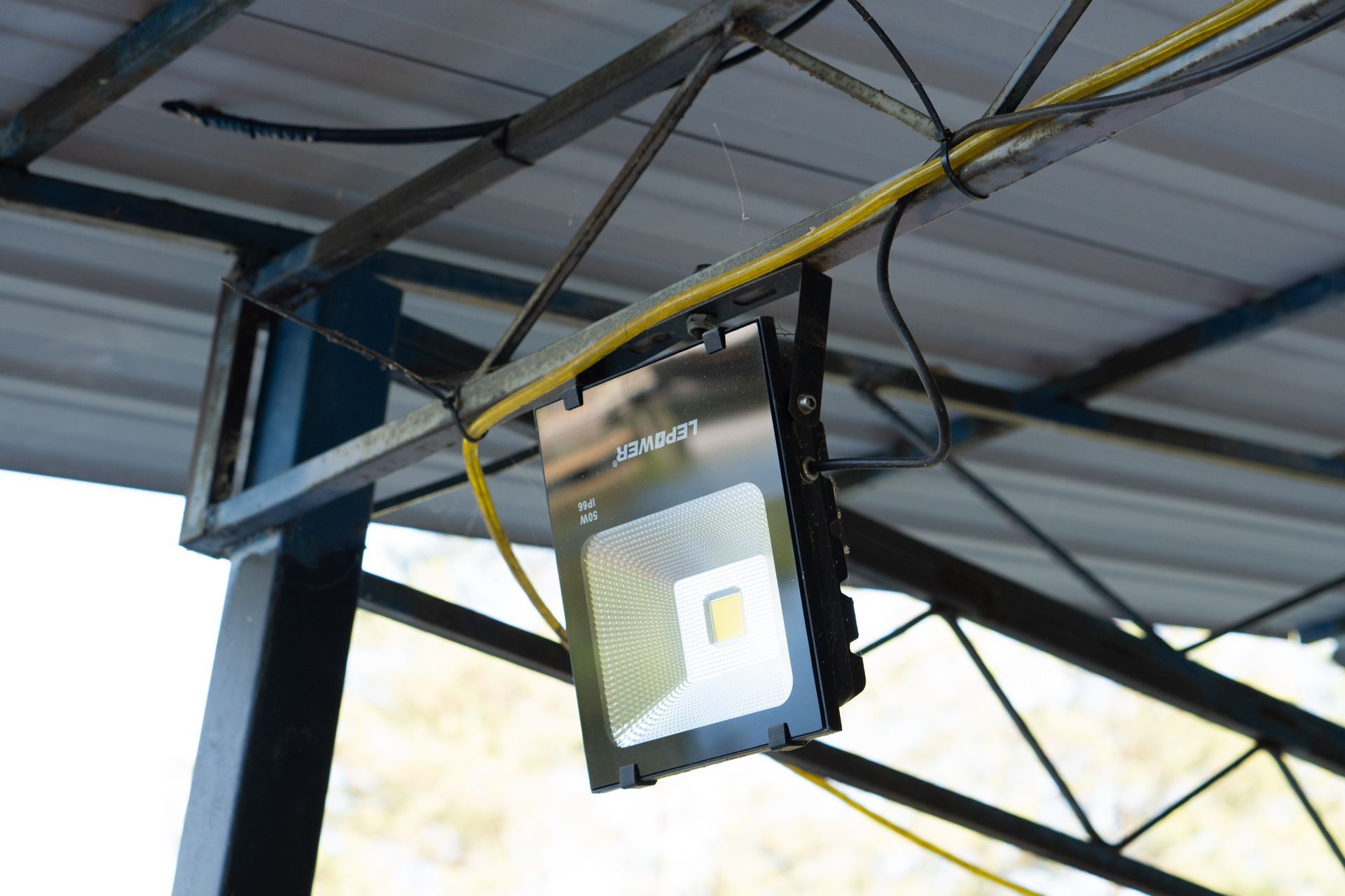 LED floodlight, mounted on metal frame, with yellow power cord.