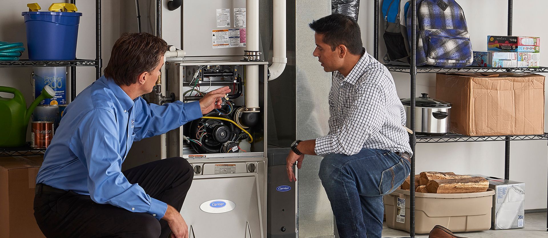 Two men are working on a heating system in a garage.