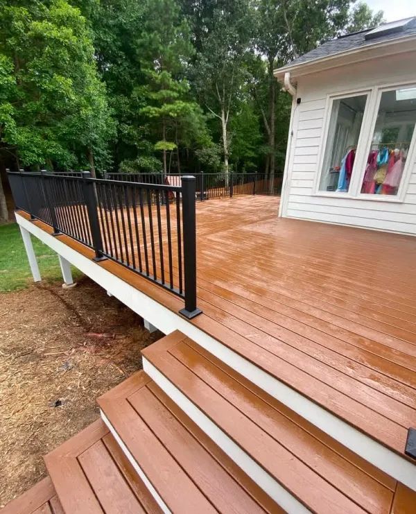 A wooden deck with stairs and a black railing
