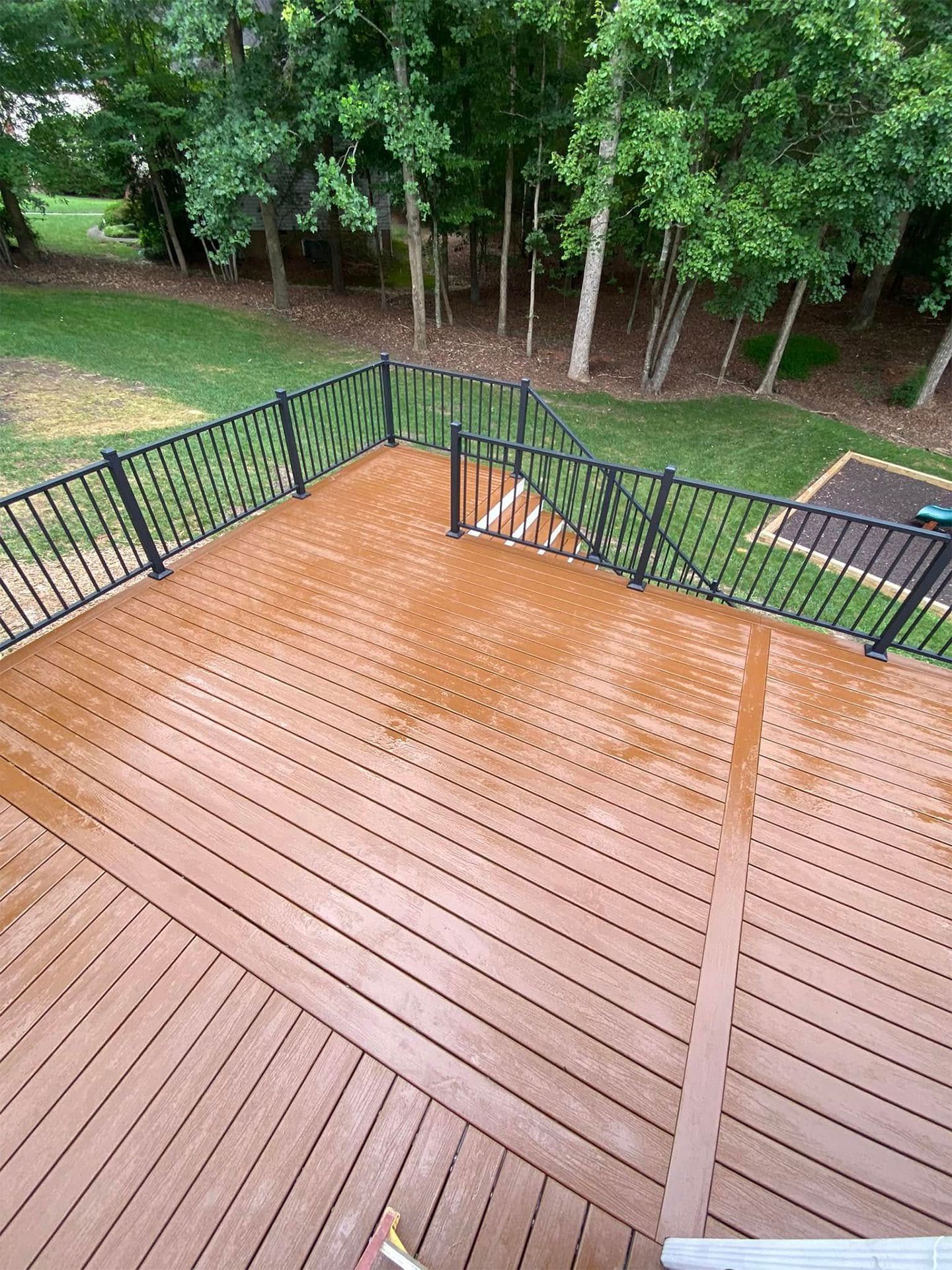 An aerial view of a wooden deck with a black railing