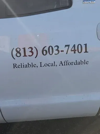 White vehicle door with phone number (813) 603-7401 and slogan “Reliable, Local, Affordable.”