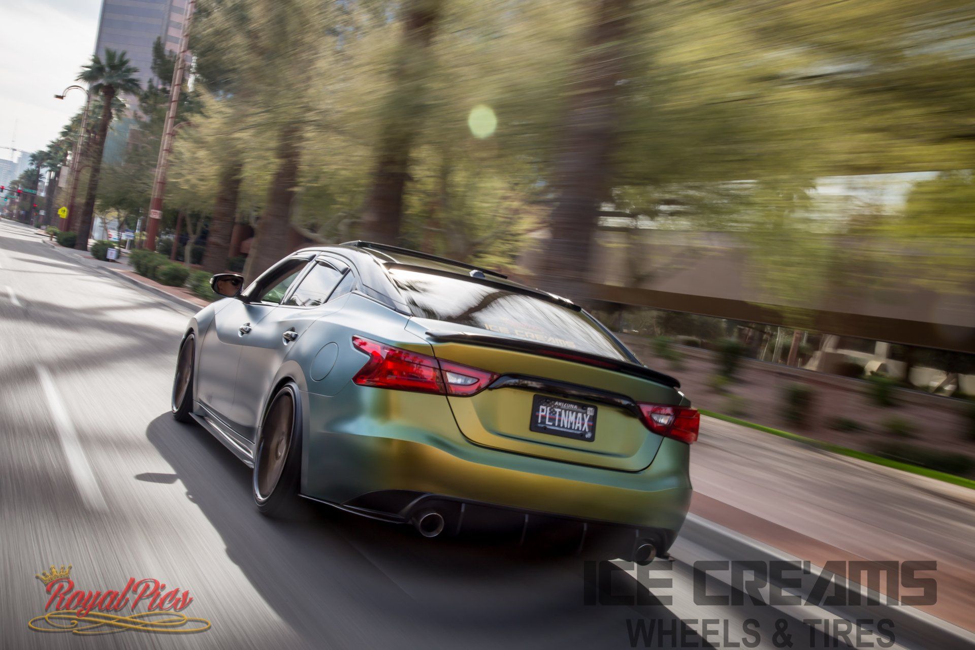 Green sports coupe driving fast on a city street, motion blur in the background
