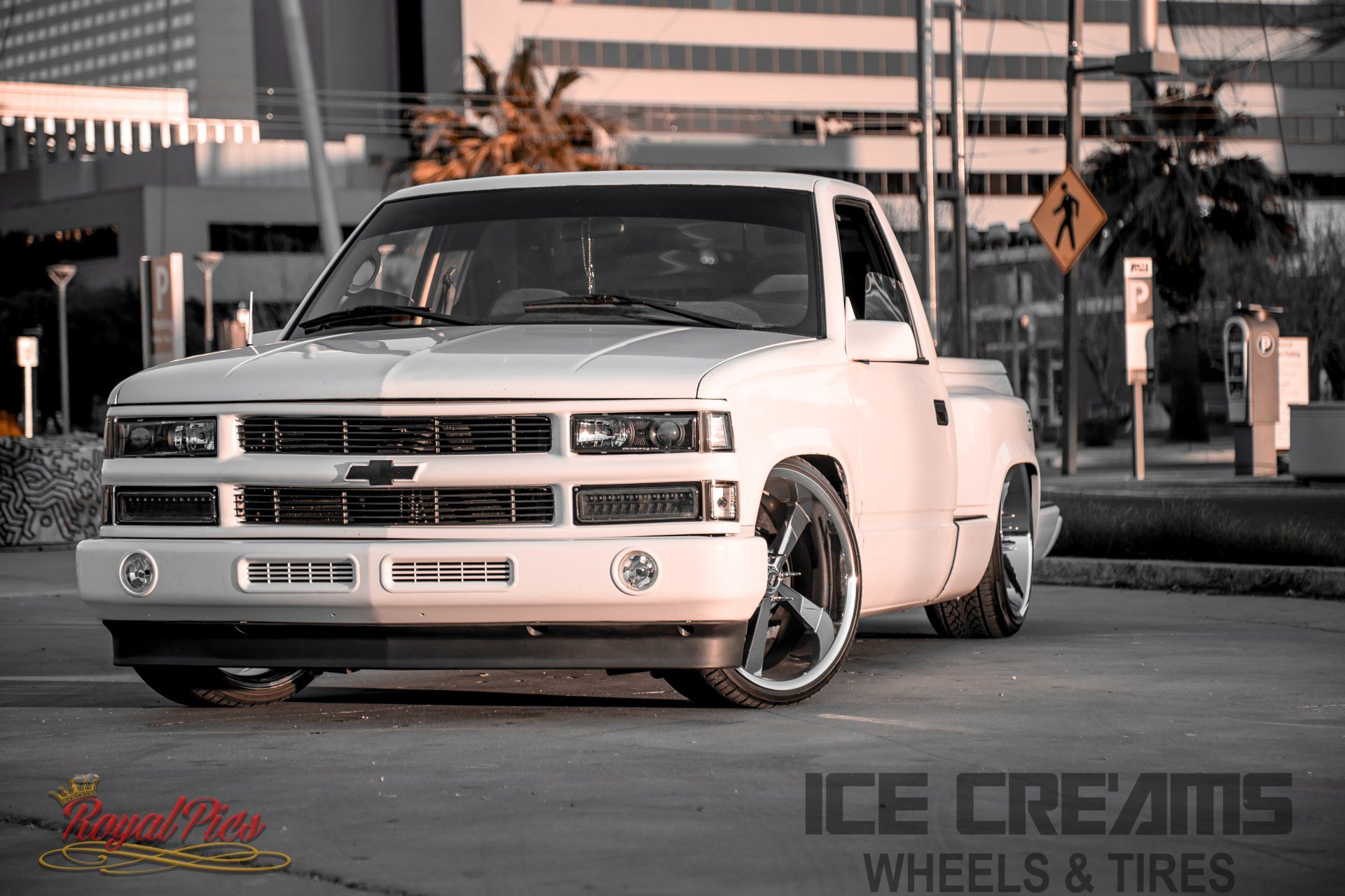 White customized pickup truck parked outdoors with lowered stance and chrome wheels