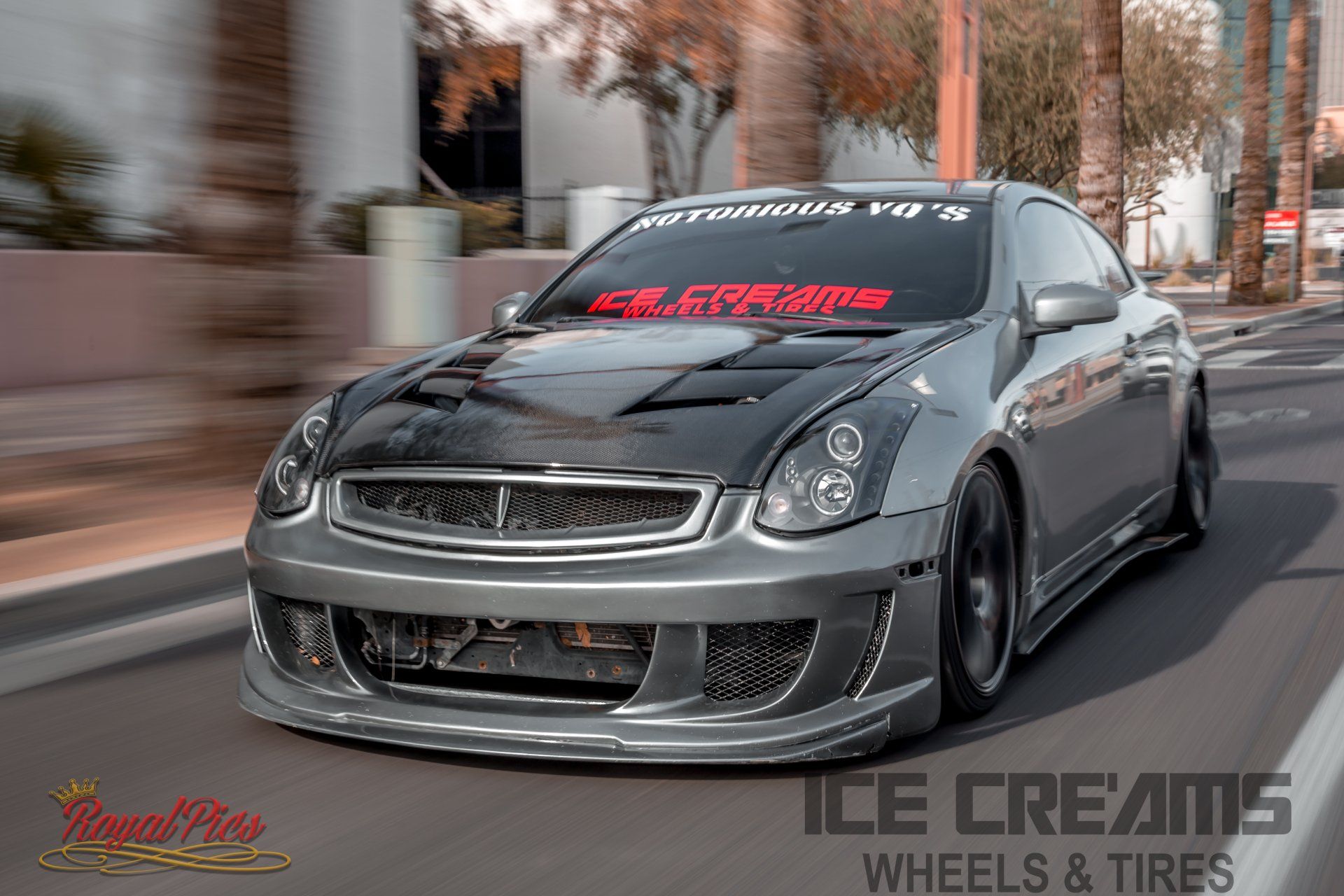 Gray customized sports car driving on a city street with motion blur and lowered body kit