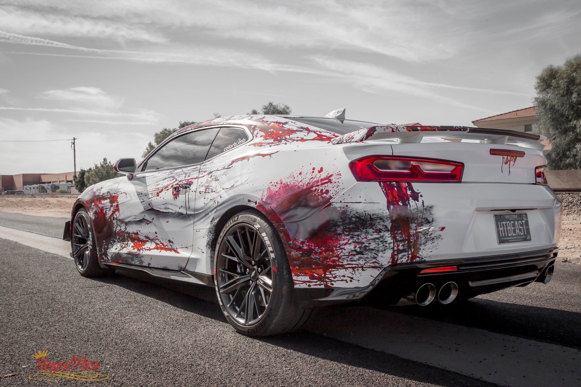 White sports car with red racing graphics parked on a road under a cloudy sky