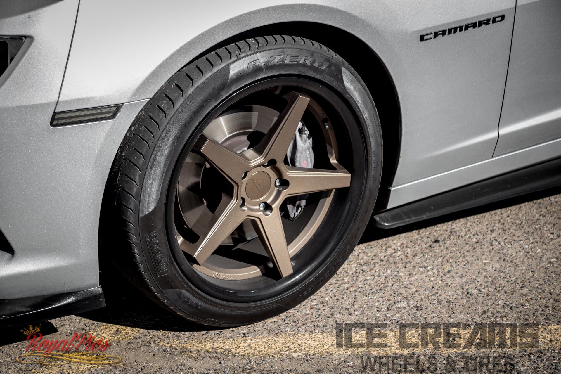 Close-up of a silver Camaro’s rear wheel with bronze five-spoke rim and low-profile tire