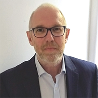 a man with a beard wearing glasses and a suit