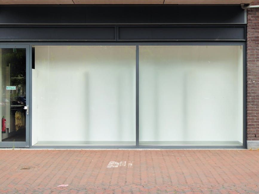 Empty commercial storefront with large glass display windows.