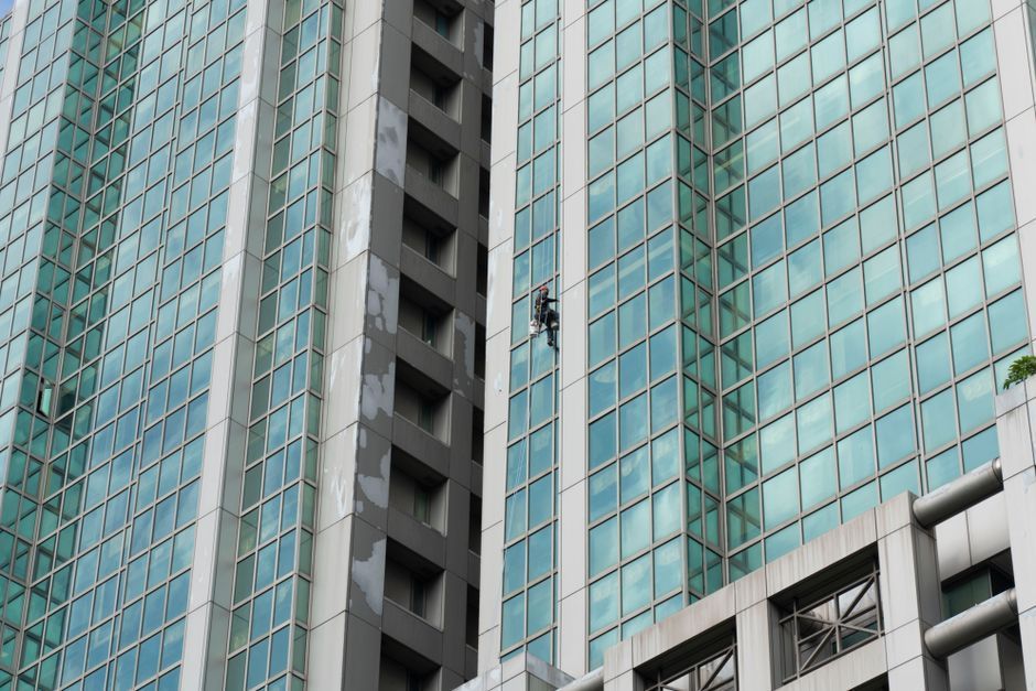 Window cleaner working on a high-rise commercial building exterior