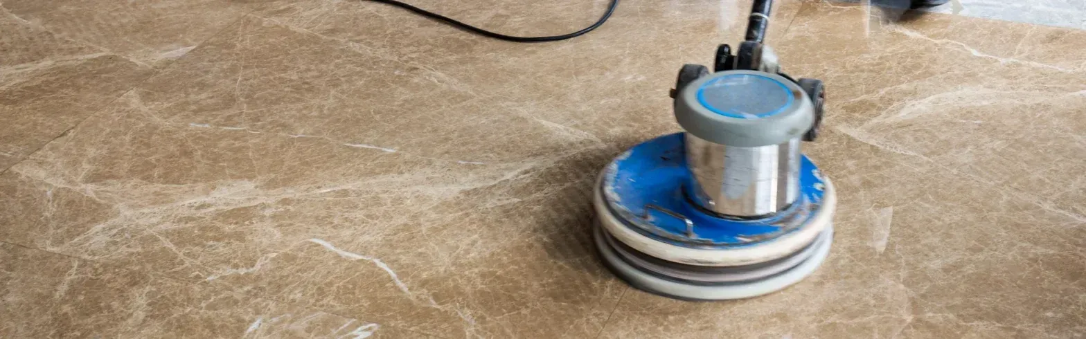 Blue floor buffer cleaning beige carpet in a room