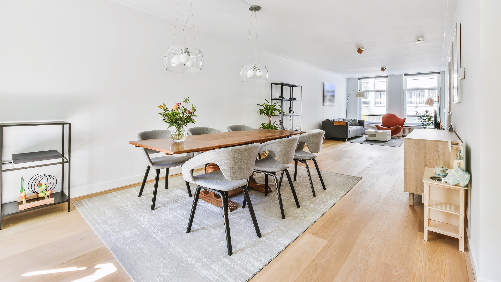 A dining room with a table and chairs in a living room.