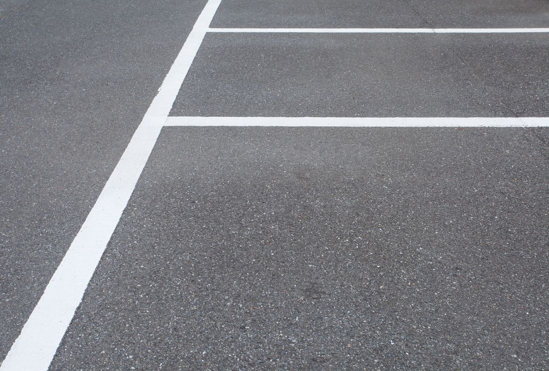 Linee bianche per il parcheggio su asfalto grigio