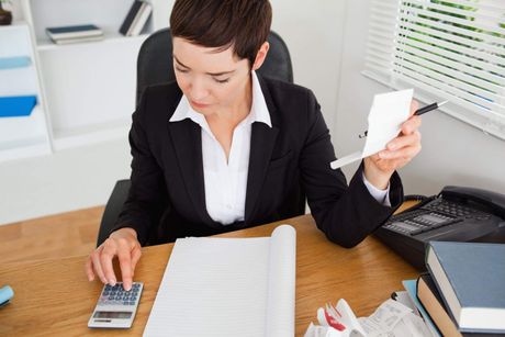 a woman sitting at a desk with a calculator