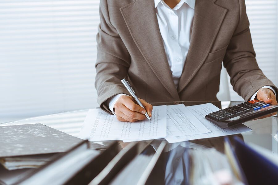 a man in a business suit sitting at a desk with a calculator and