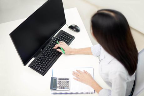 a woman sitting at a desk typing on a keyboard