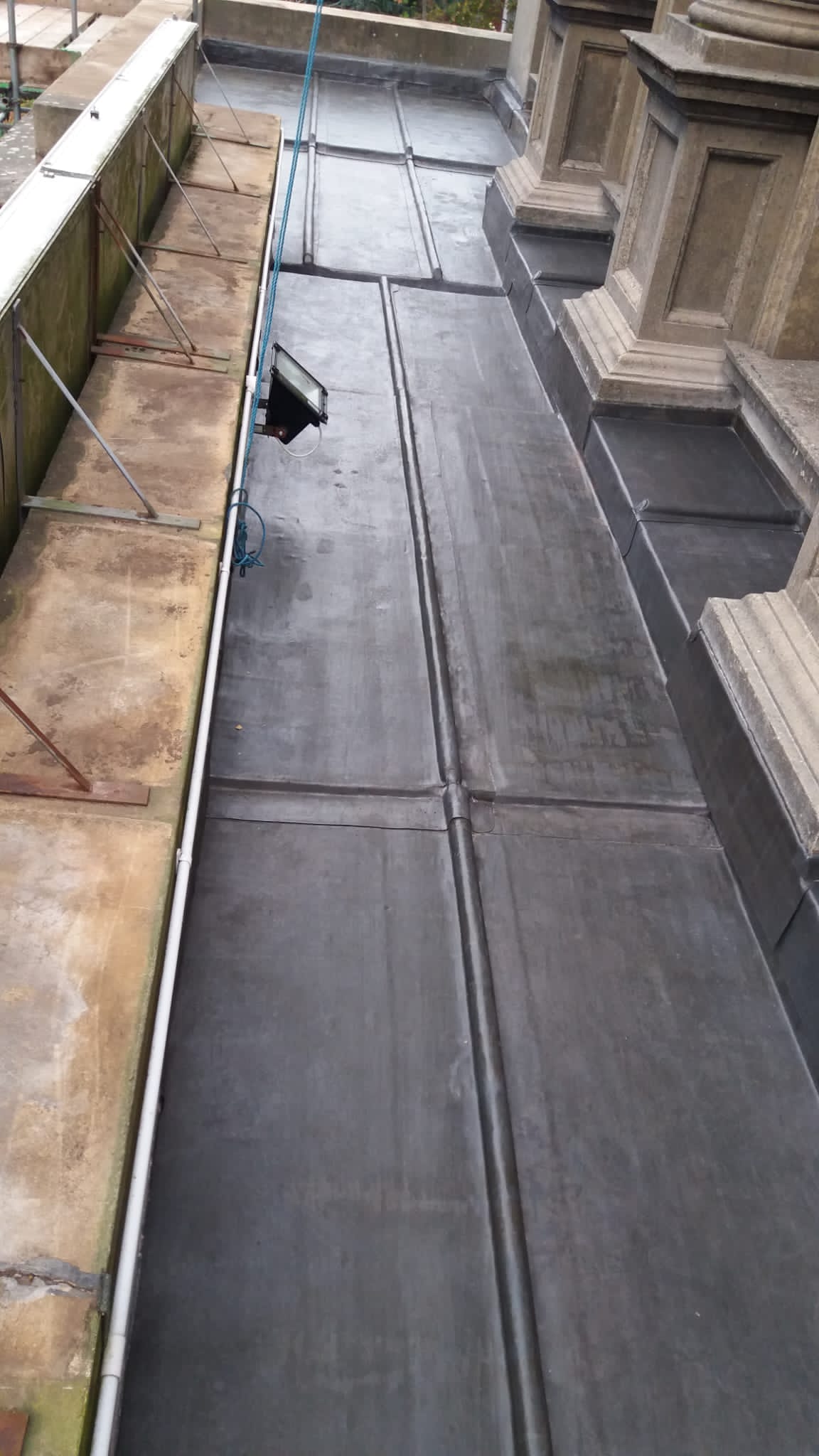 A close up of a roof with a drain on it.