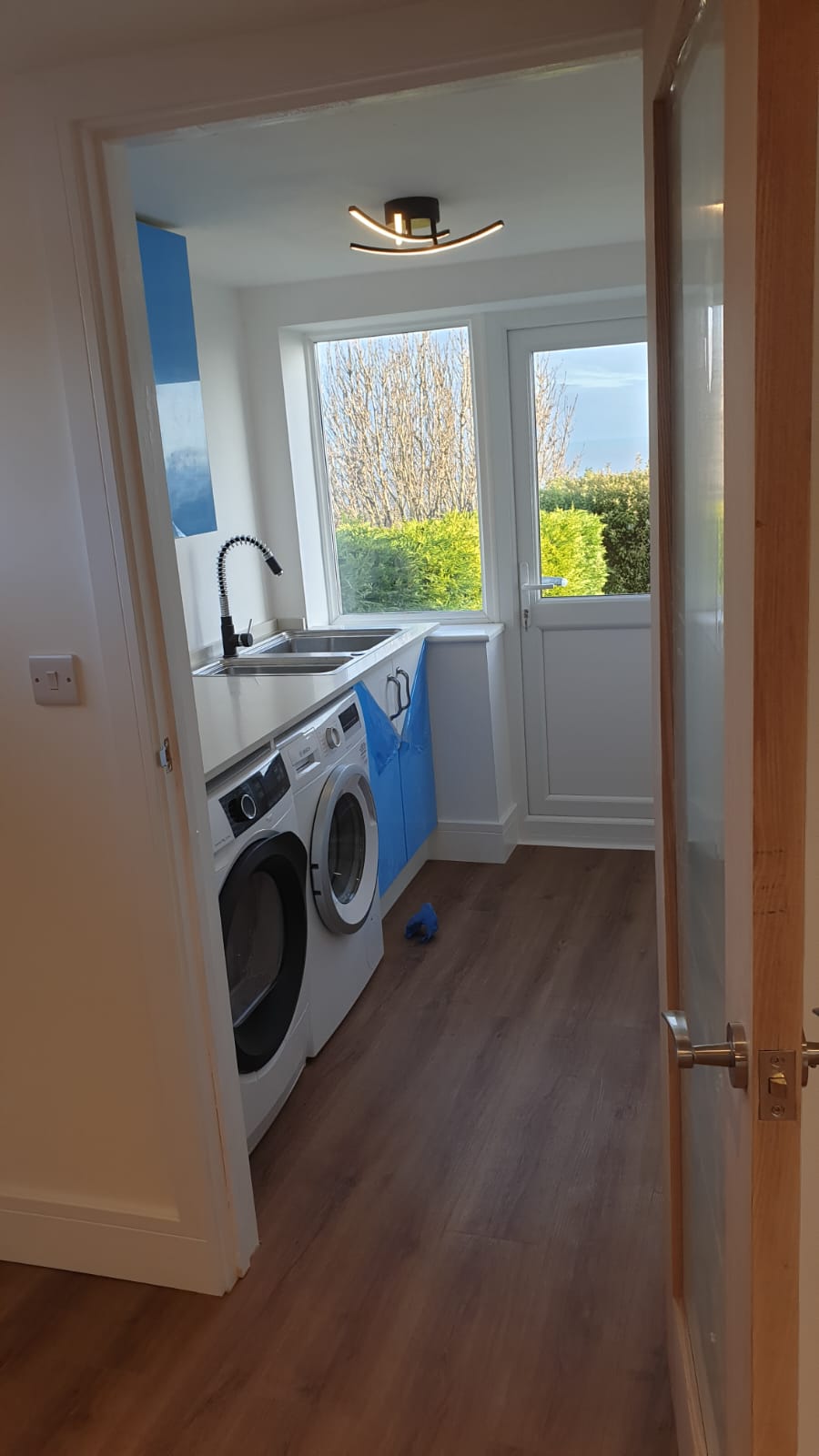A laundry room with a washer and dryer and a window.