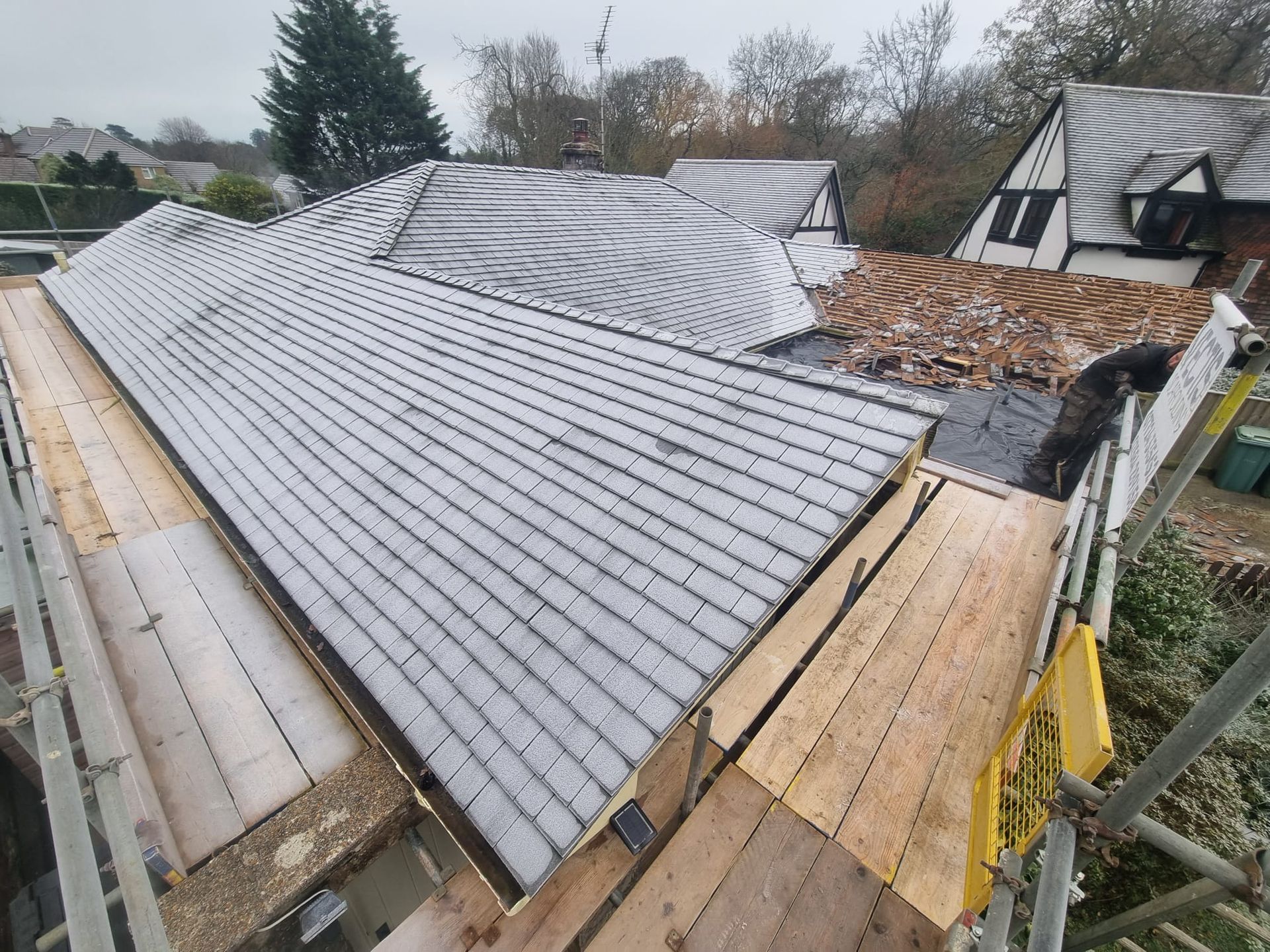The roof of a house is being repaired with scaffolding.