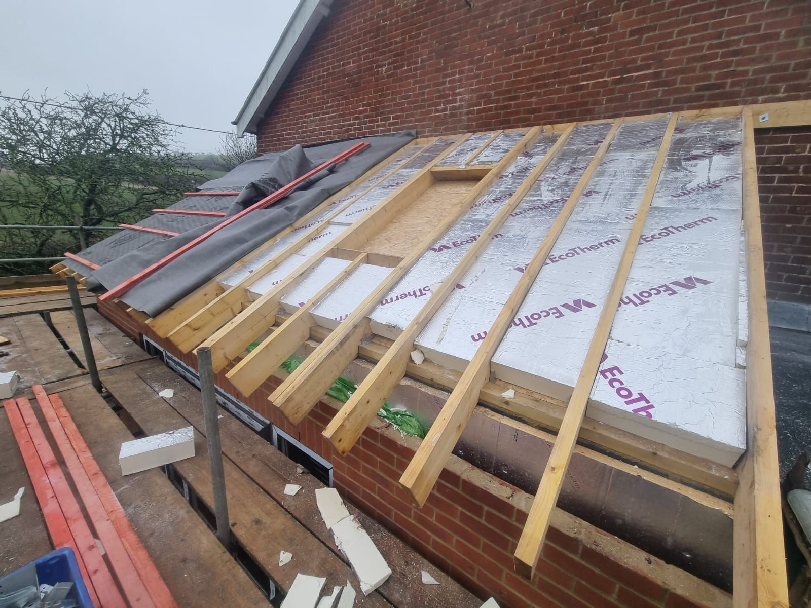 A roof is being built on top of a brick building.