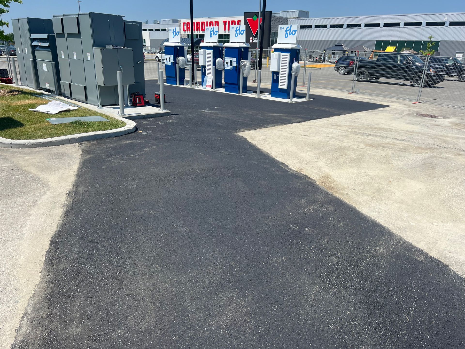 Service au volant en plein air avec pompes bleues et bornes de service à côté d'un parking par une journée ensoleillée