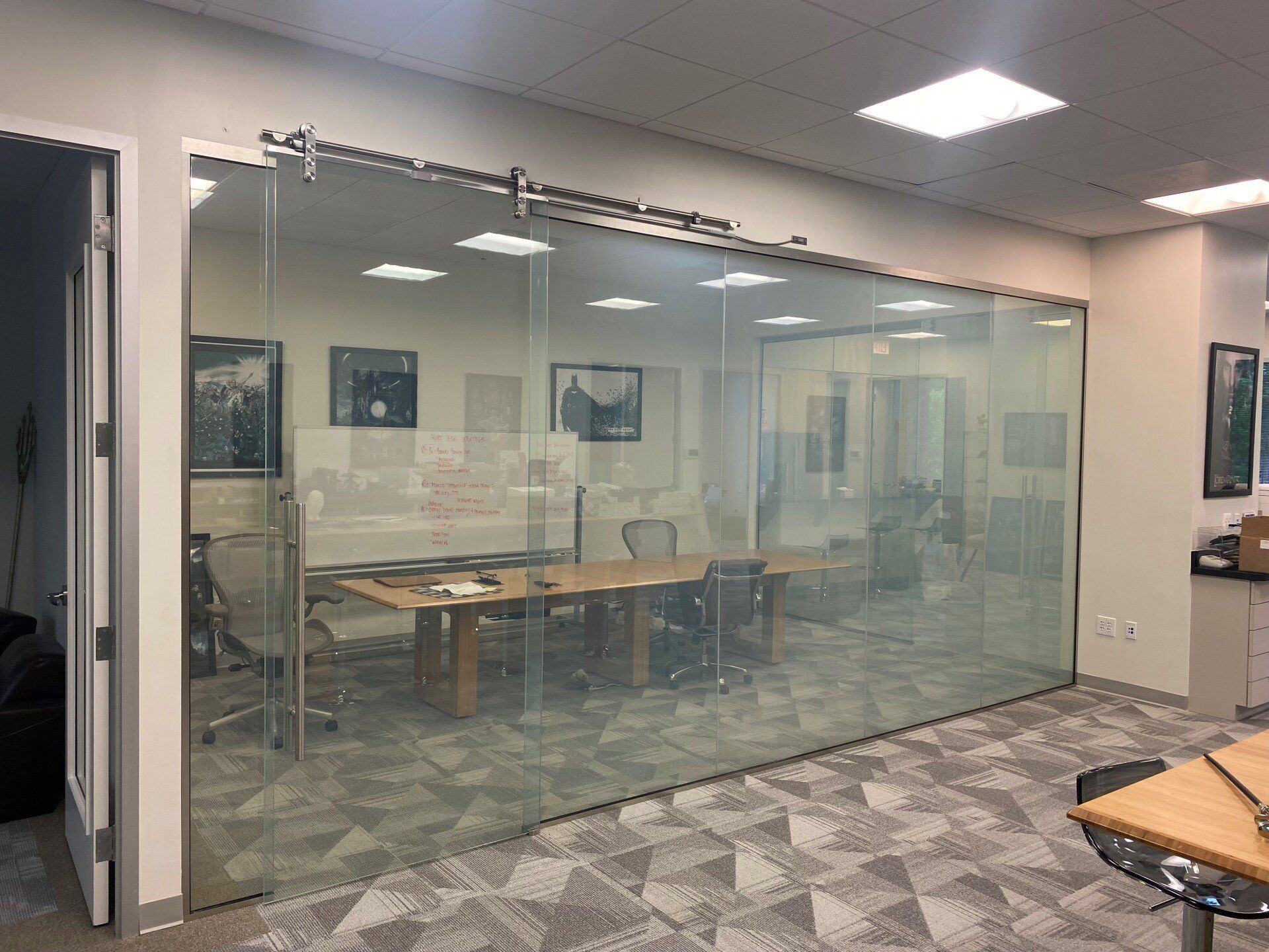 A conference room with sliding glass doors and a table and chairs.
