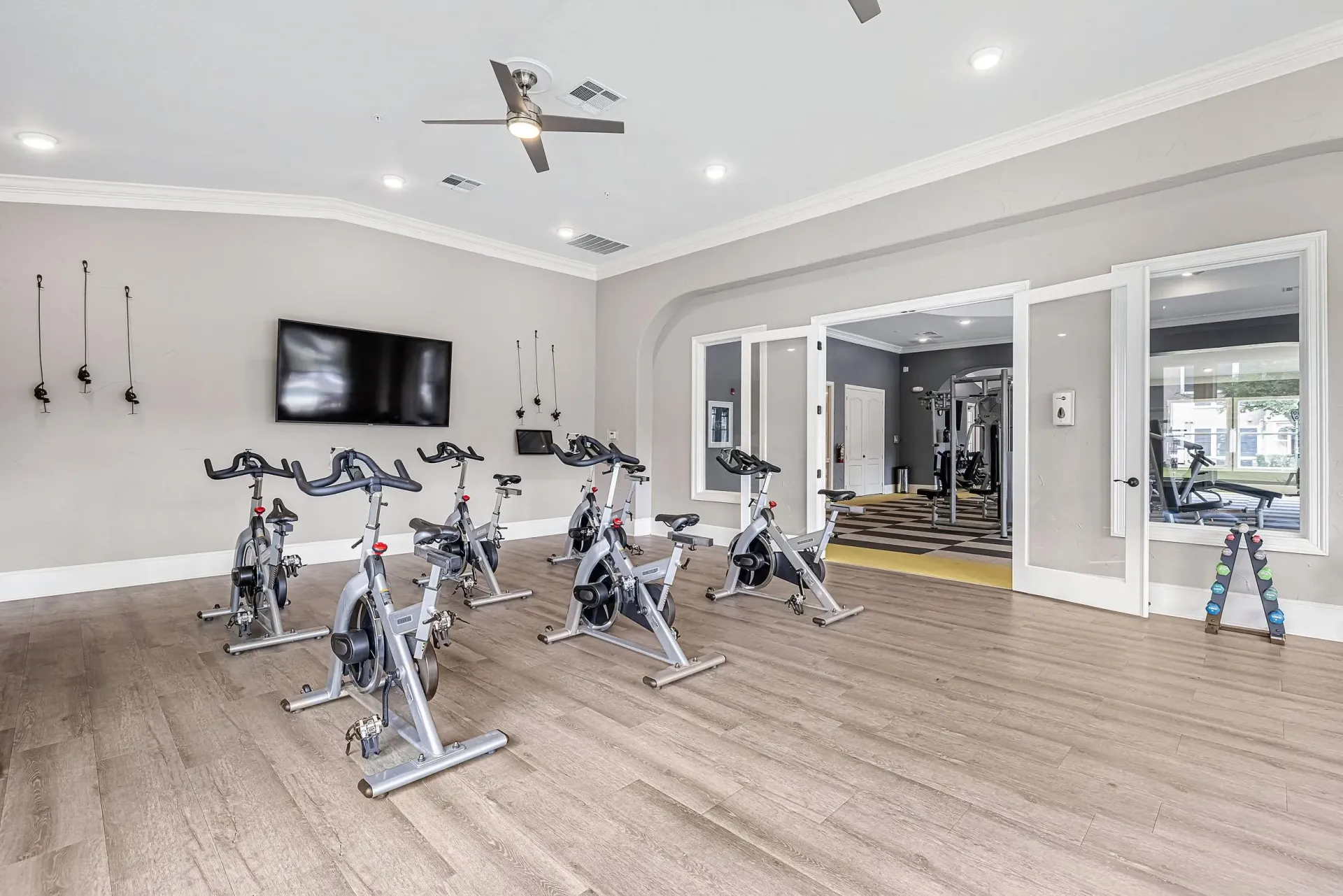 Spin bikes and weight machines in a well-lit fitness center.