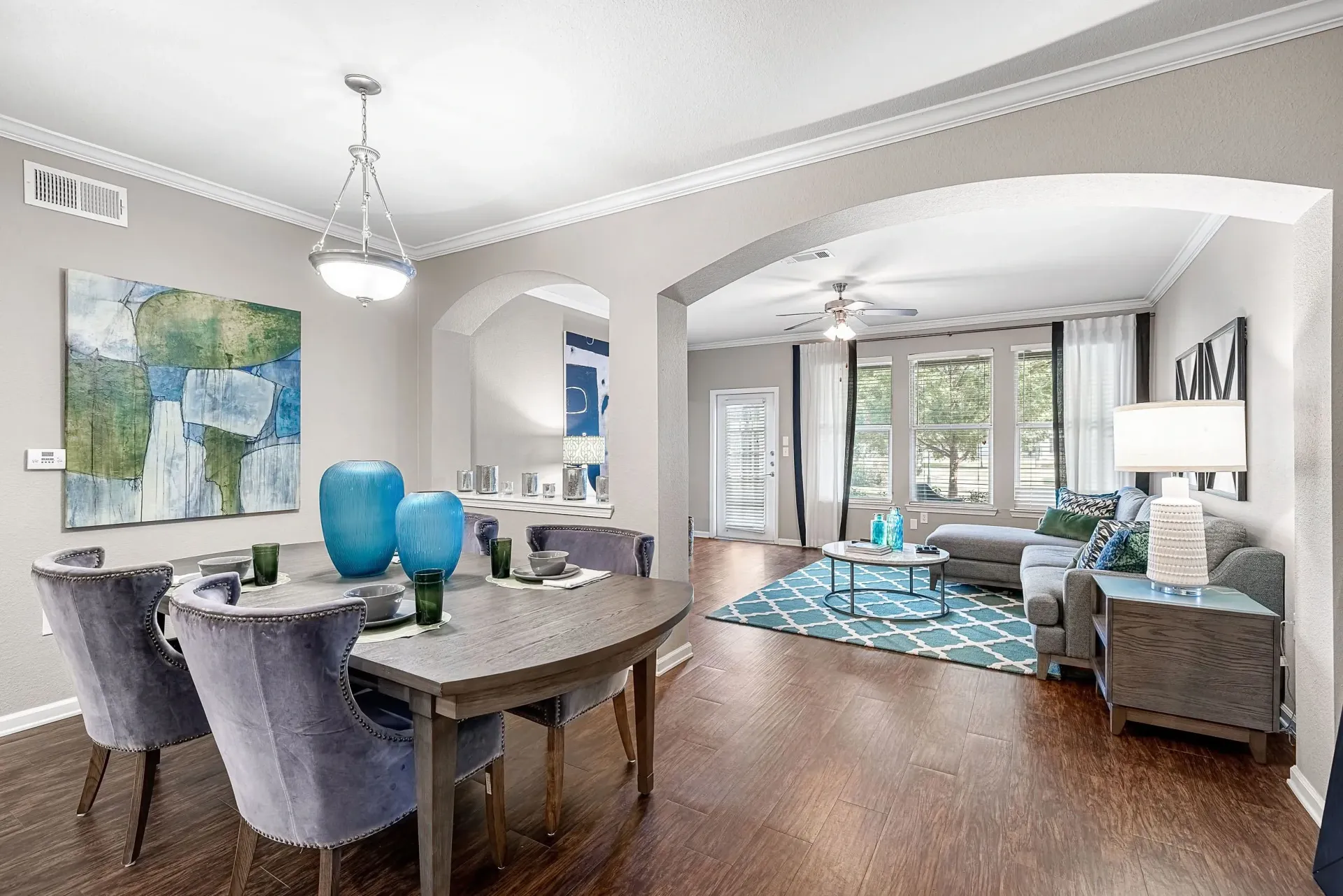 Dining area with a table and chairs next to a living room with a sectional couch.