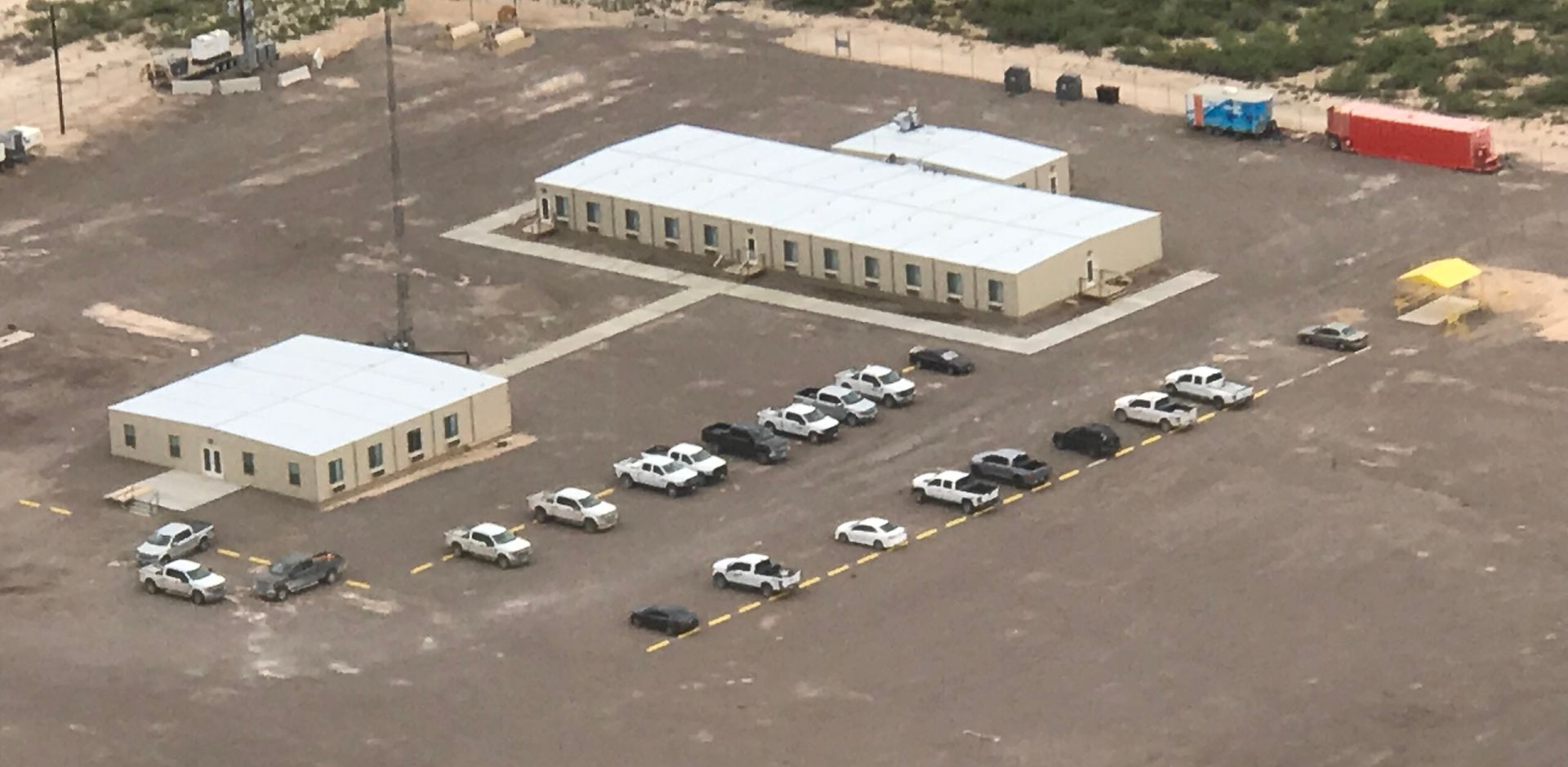 An aerial view of a parking lot with cars parked in a row