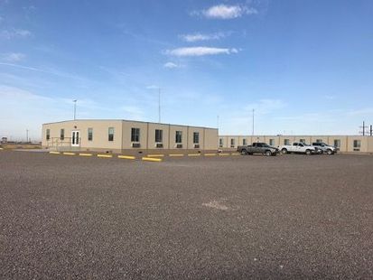A large building with a lot of cars parked in front of it.