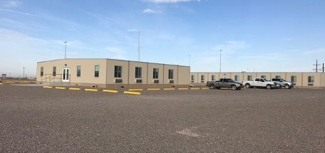 A large building with a lot of cars parked in front of it.