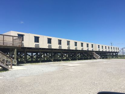 A large building on stilts with stairs leading up to it