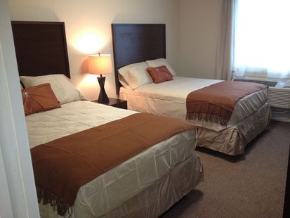 A hotel room with two beds and a window