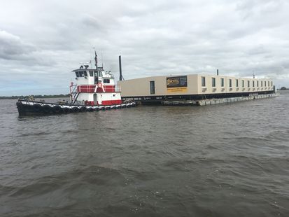 A tugboat is pulling a large barge in the water.