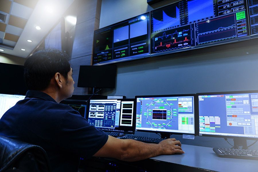 A Man is Sitting in Front of a Computer Monitor in a Control Room — Computers NQ in Aitkenvale, QLD
