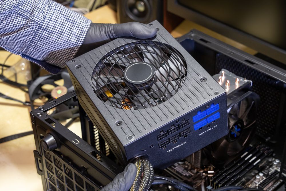 A Person is Installing a Power Supply Into a Computer Case — Computers NQ in Aitkenvale, QLD