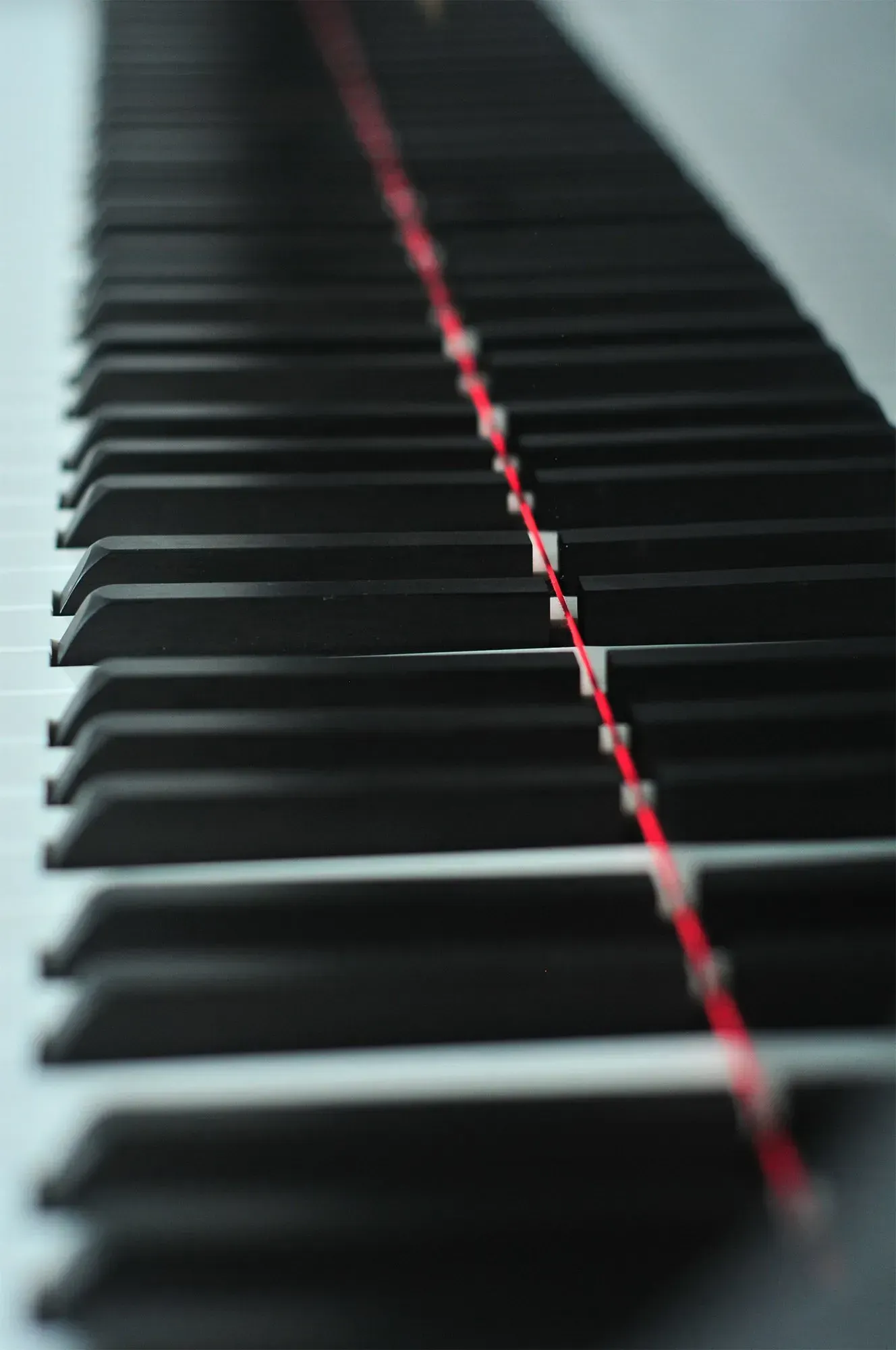 A close up of a piano keyboard with a red line