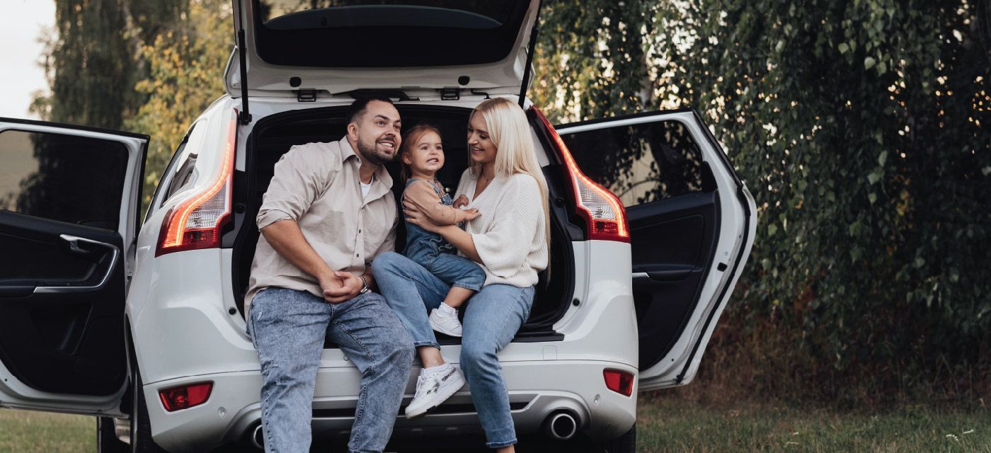 A family is sitting in the back of a car.
