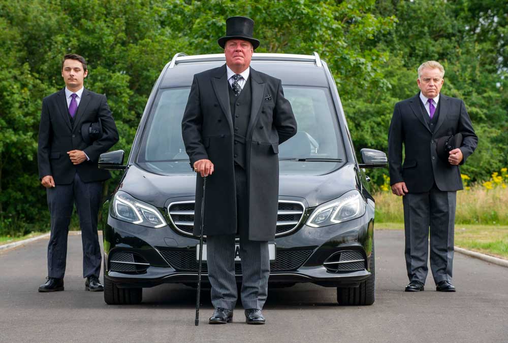 three undertakers with hearse