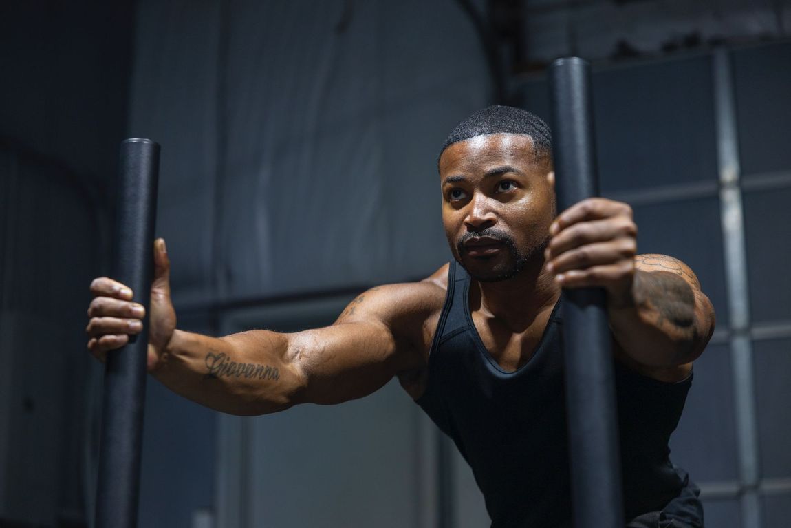 Your Trainer Trey Johnson at 360 image fitness exercising to build strength and muscle in all black workout clothes