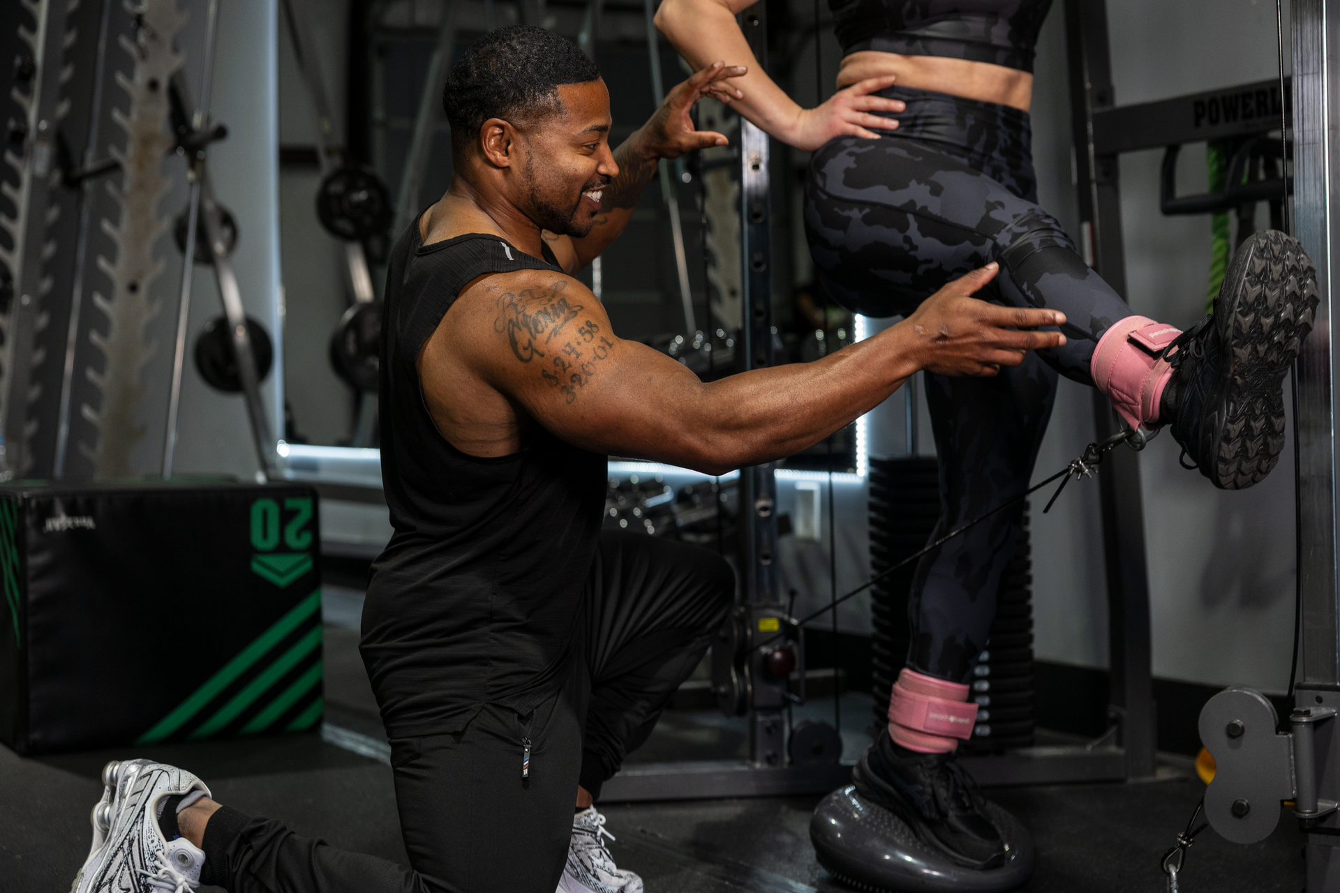 Fitness challenge registration from 360 Image Fitness. Trainer Trey Johnson in black shirt helping training client exercise