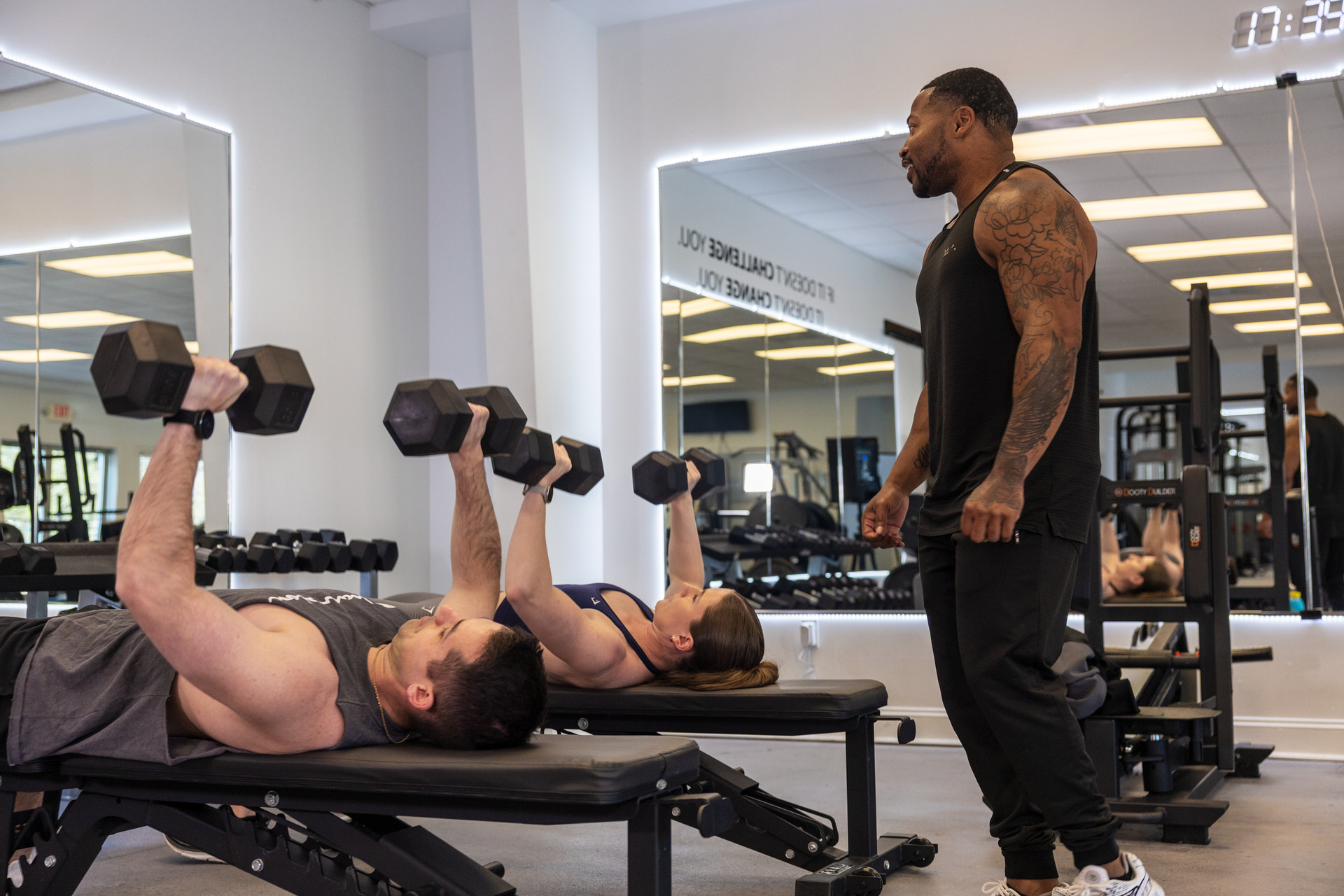 Trainer Trey Johnson at 360 Image Fitness training two clients in a couples training session working on arm strengthening