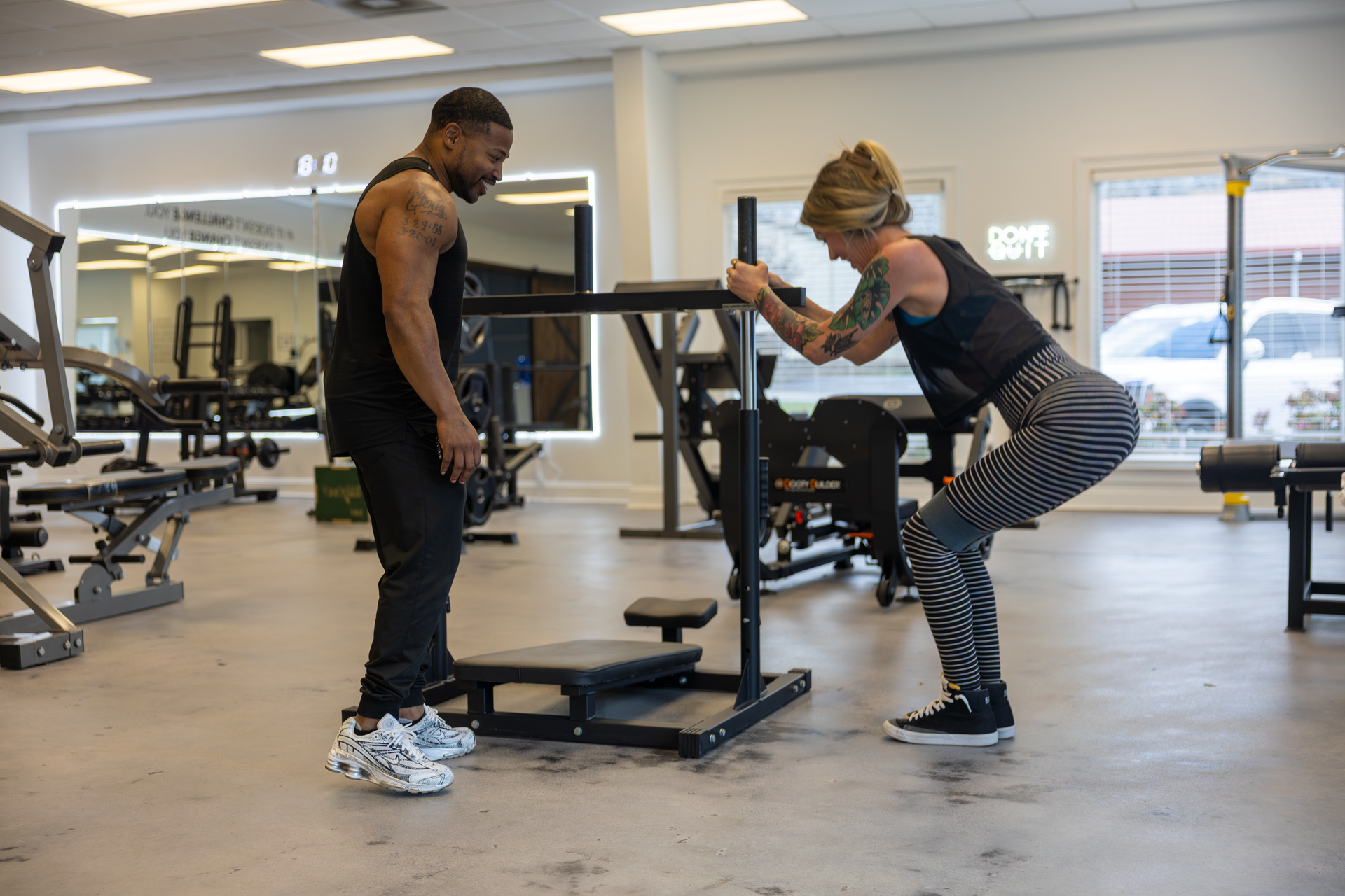 Trey Johnson at 360 Image Fitness gym in Watkinsville, GA helping female client with leg strengthening exercises at gym