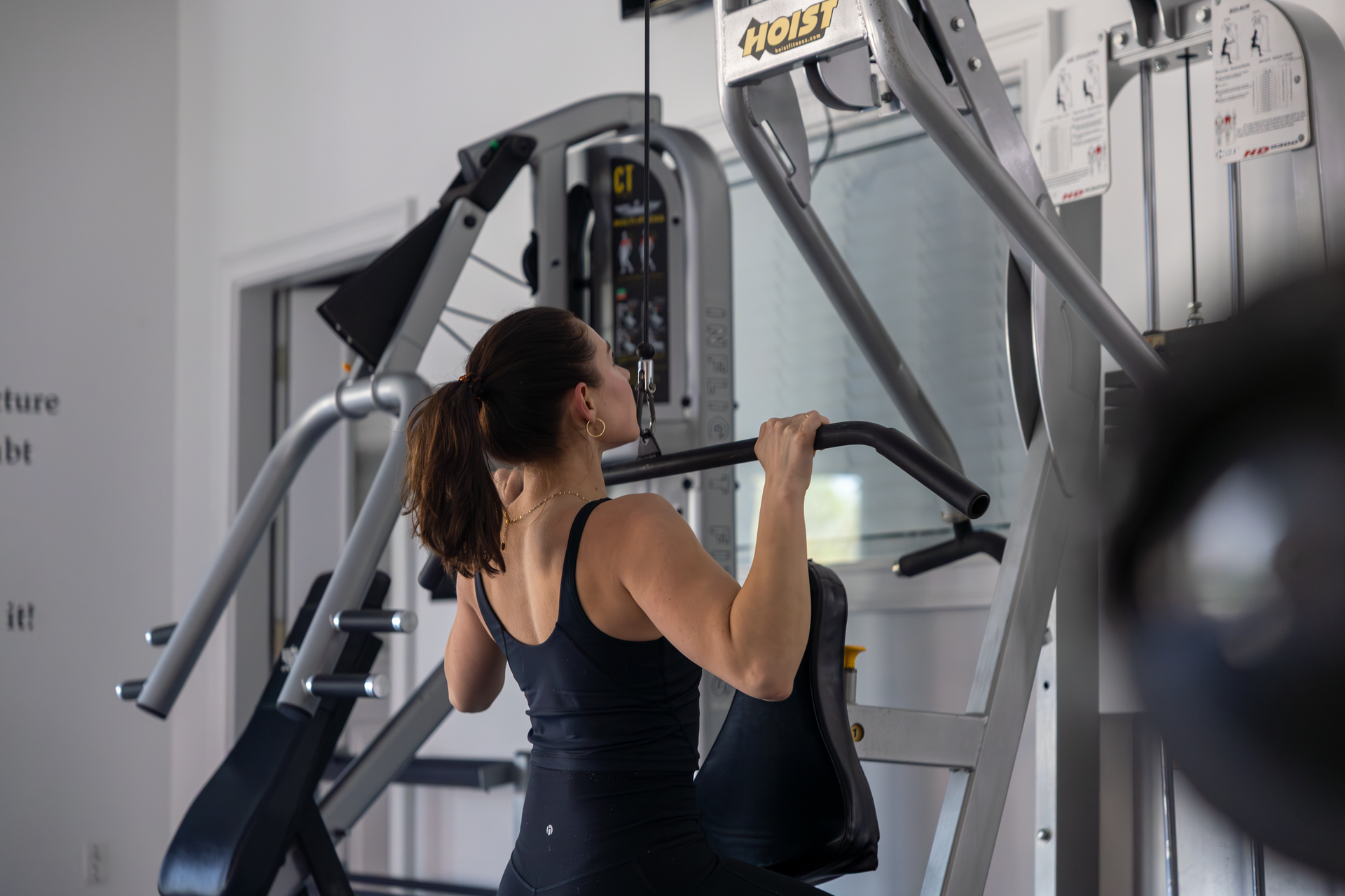360 image fitness personal training female, brown haired client doing tricep strength exercises wearing gym clothes