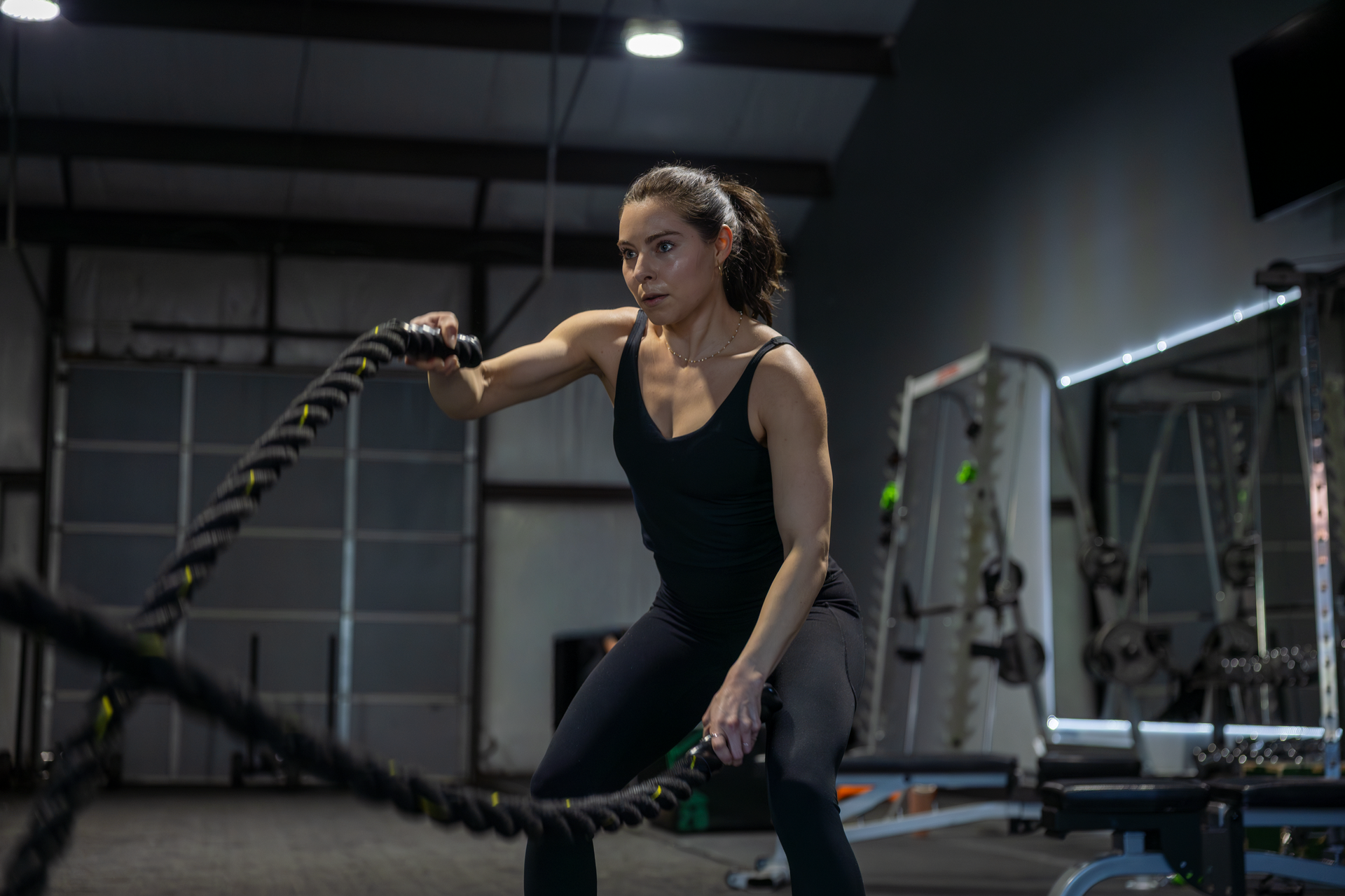 360 image fitness personal training female, brown haired client doing rope arm strength exercises wearing gym clothes