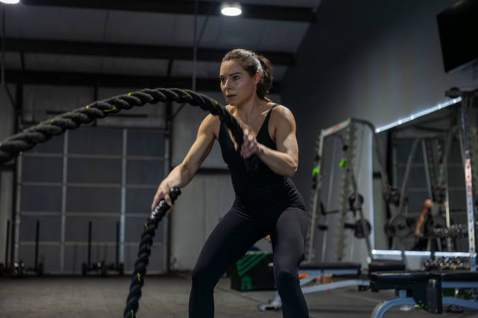 360 image fitness personal training female, brown haired client doing rope strength exercises wearing gym clothes