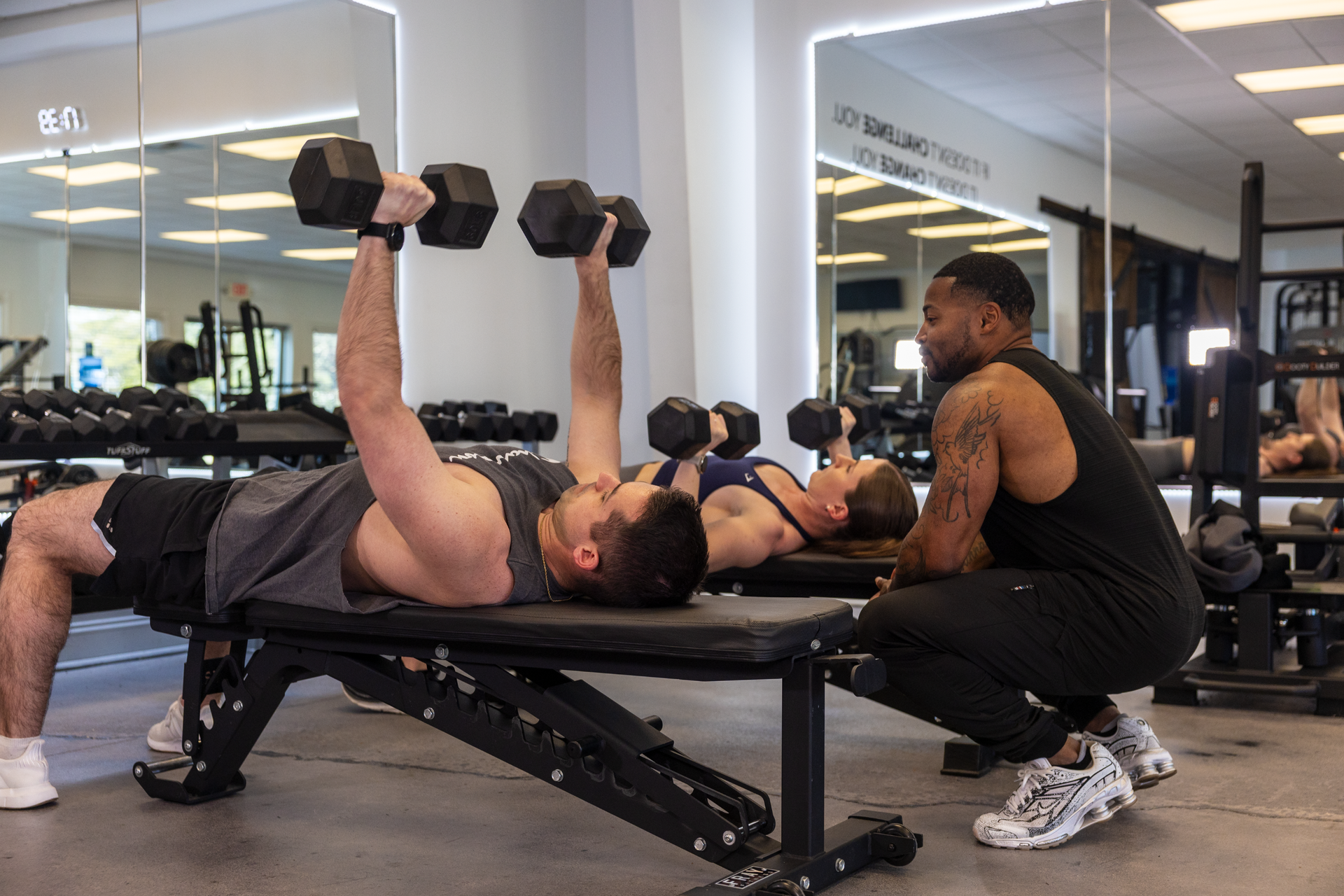 Trainer Trey Johnson at 360 Image Fitness gym in Watkinsville, GA helping couples group clients with arm strengthening