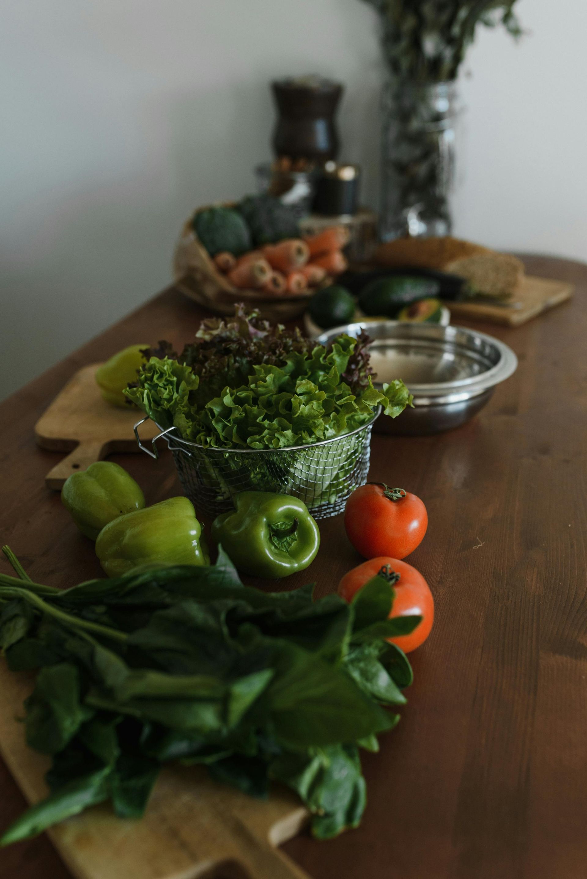 Fresh green herbs and vegetables arranged on a wooden table with bowls in the background for 360 image fitness gym nutrition