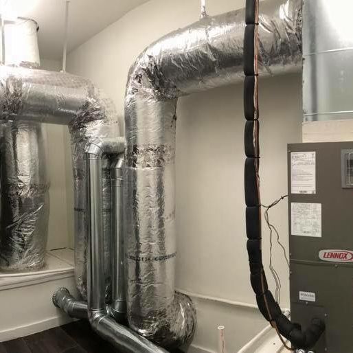 A room with a lot of aircon pipes and a furnace.
