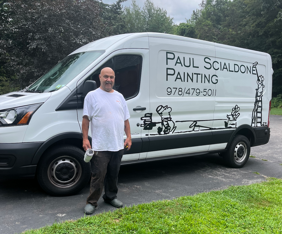 A man is standing in front of a paul scialdone painting van.