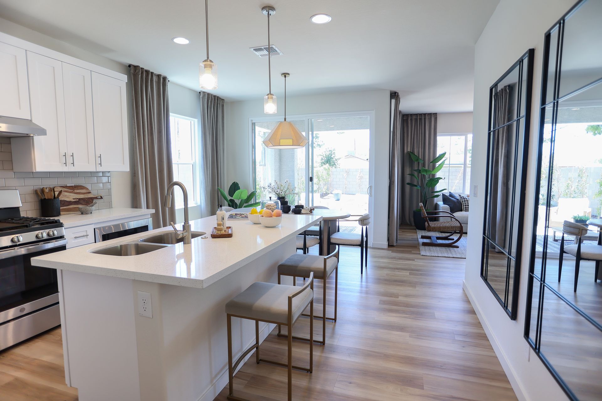 Bright modern kitchen with white island, stainless appliances, and open view to dining and living areas